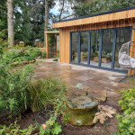 Outdoor timber constuction with modern sitting area inside surrounded by new plants